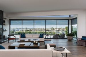 Waterfront living room with Savant motorized shades and harbor views