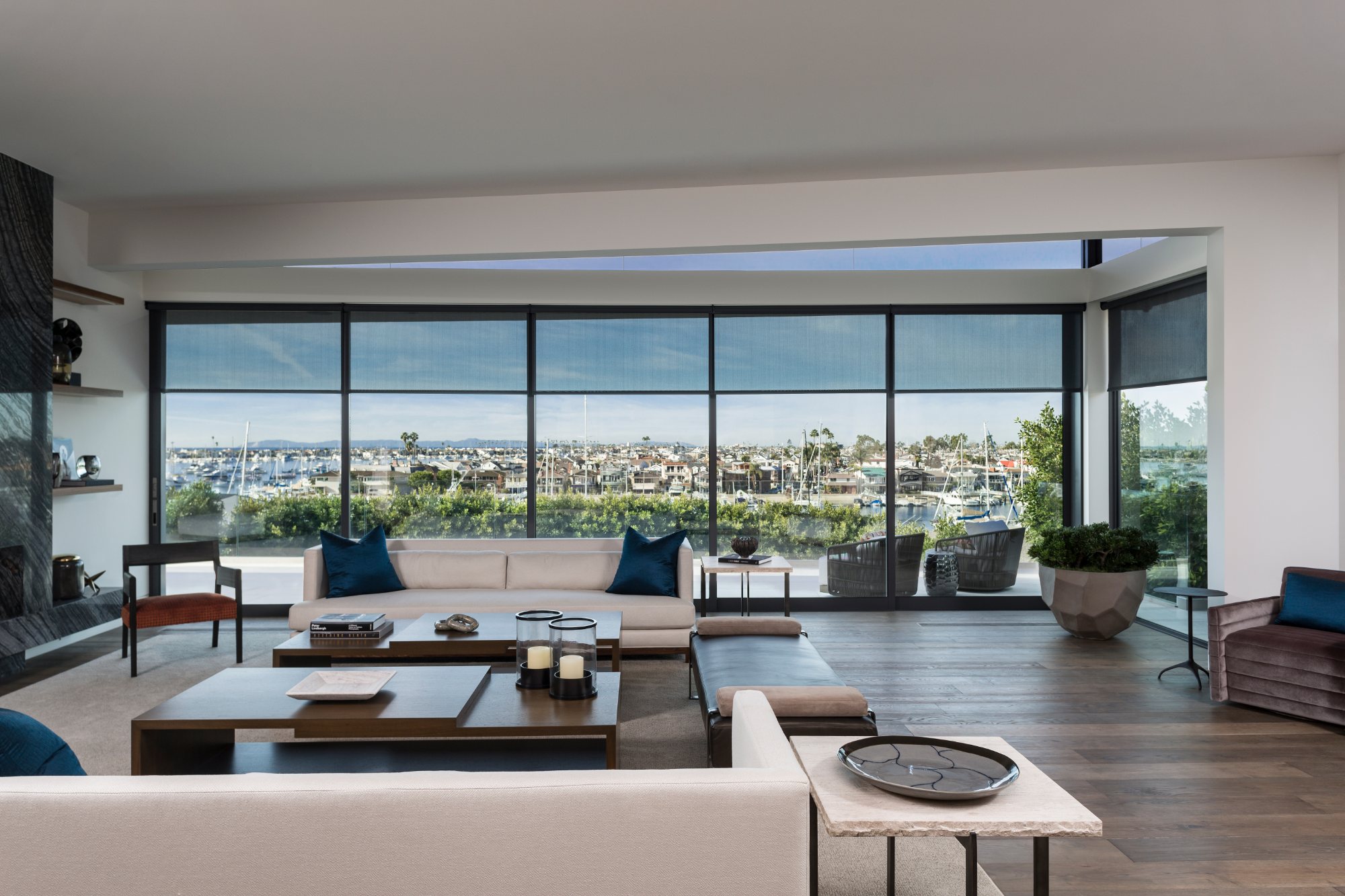 Waterfront living room with Savant motorized shades and harbor views